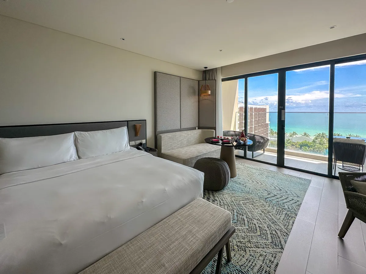 Wood and grey modern hotel room interior with open balcony door at Crowne Plaza Phu Quoc