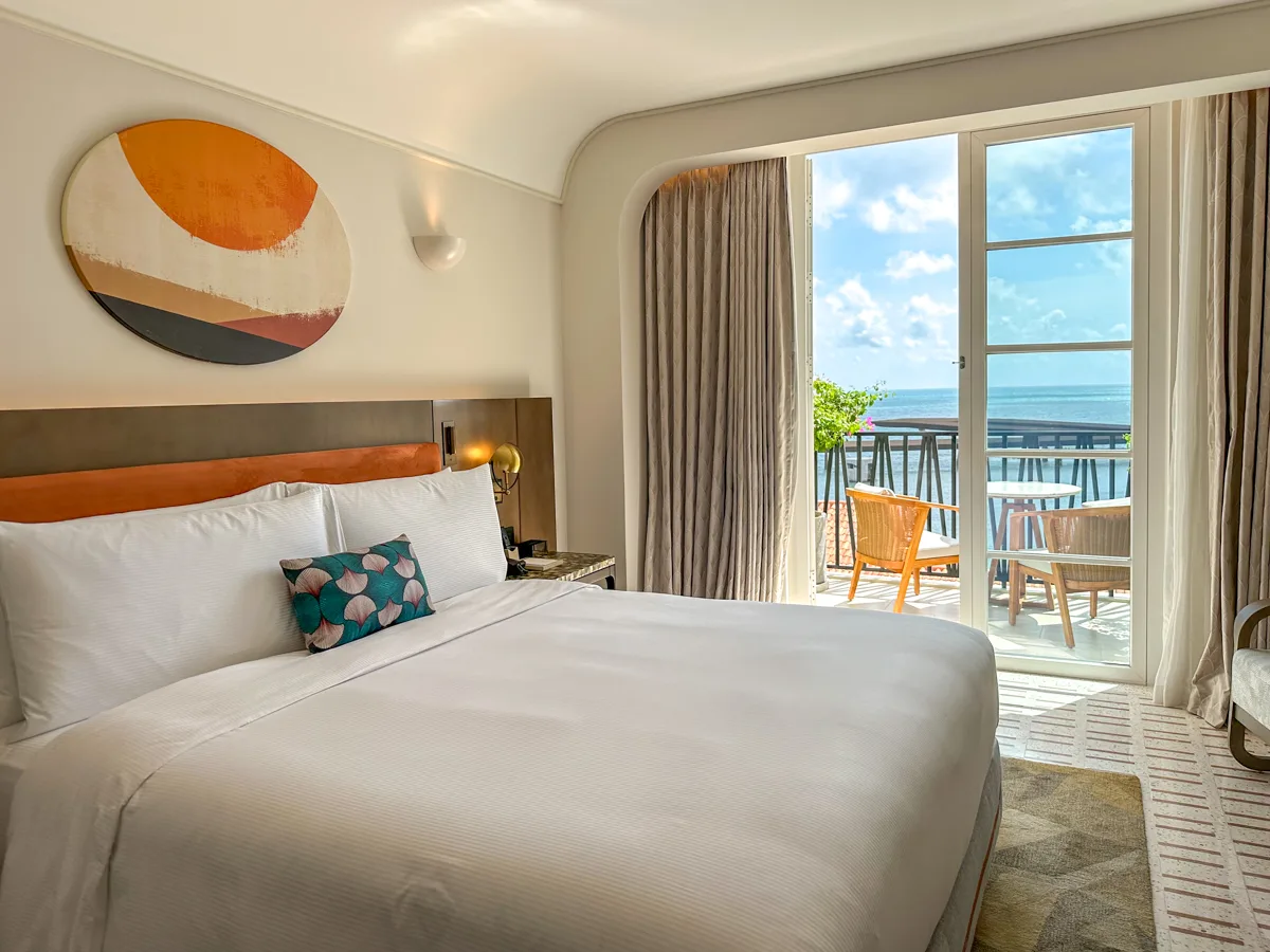 Bedroom with an ocean-view balcony at La Festa Phu Quoc, Curio Collection by Hilton