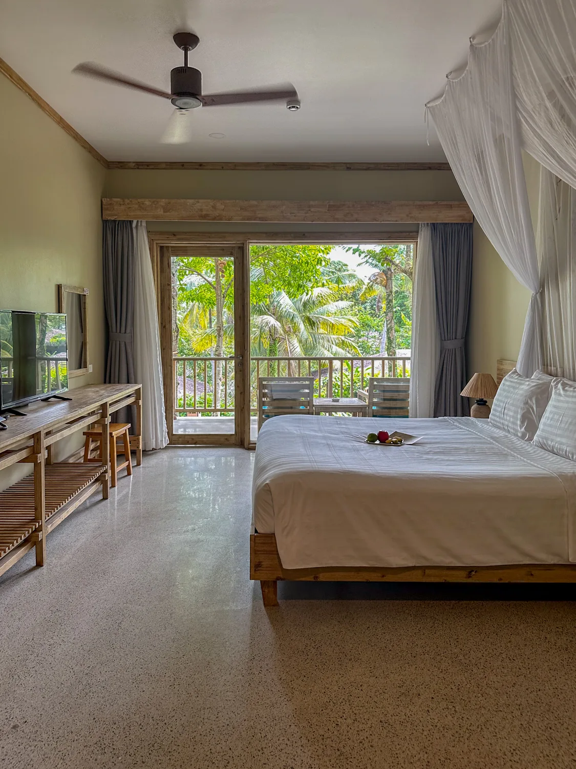 Bedroom with a canopy bed and jungle view balcony at Lahana Resort Phu Quoc & Spa