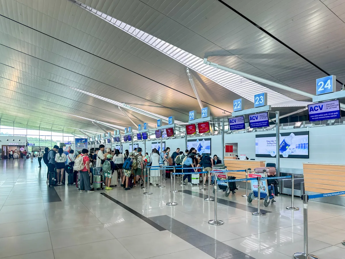 Travelers with luggage queuing at check-in counters at Phu Quoc International Airport