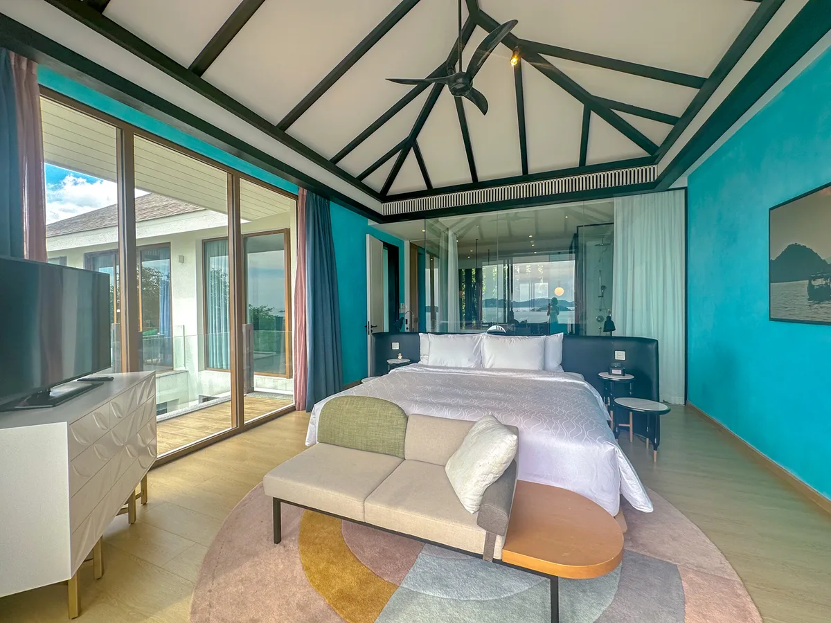 Upstairs bedroom with an ocean-view window and teal walls in an Eden Retreat Villa at Premier Village Phu Quoc