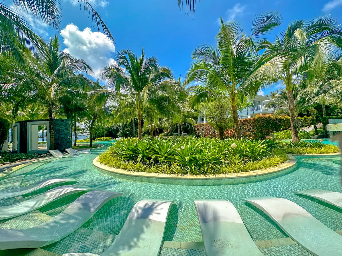 Lagoon-style pool with a circular planted island and wave-shaped loungers at Premier Village Phu Quoc