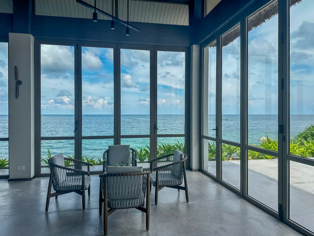 Lobby lounge seating with floor-to-ceiling ocean-view windows at Premier Village Phu Quoc