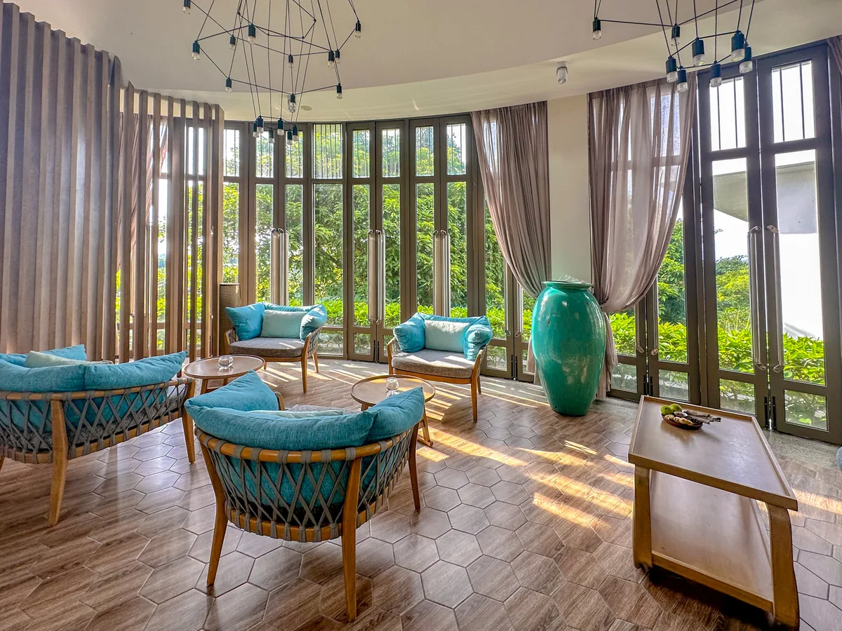 Spa waiting lounge with floor-to-ceiling garden-view windows at Plumeria Spa, Premier Village Phu Quoc