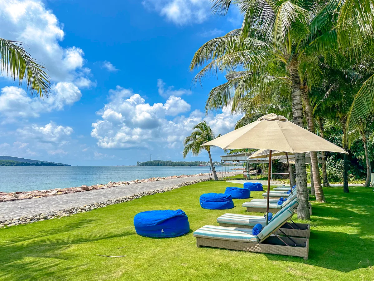 Private beach with blue bean bags, loungers, and umbrellas at Premier Village Phu Quoc