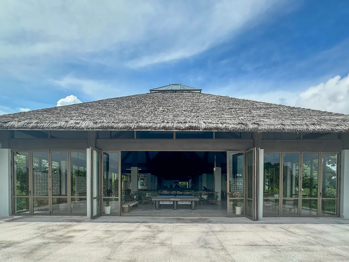 Thatched-roof lounge building exterior with a pool table visible inside at Premier Village Phu Quoc