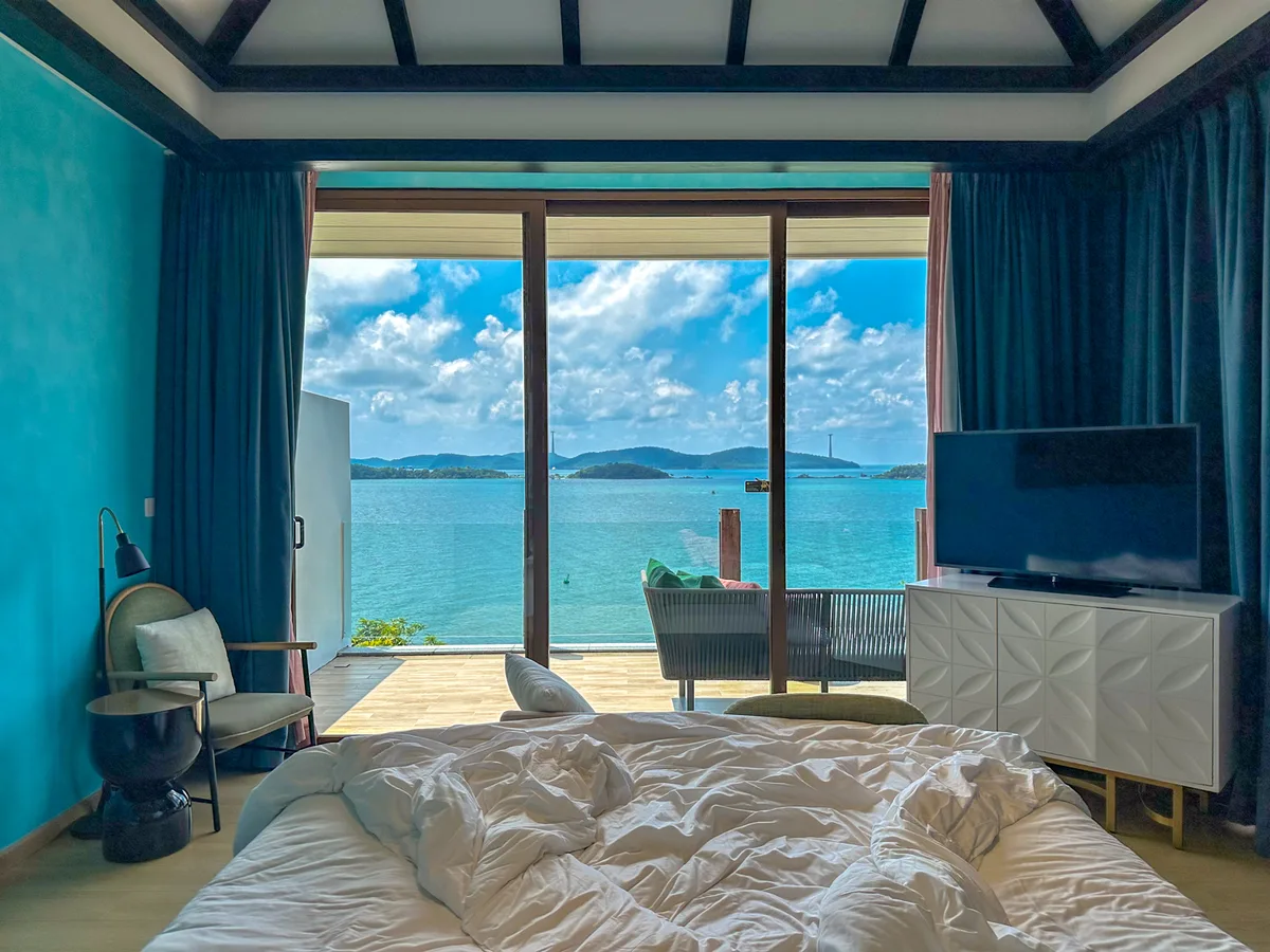 Villa bedroom with a panoramic ocean view through floor-to-ceiling windows at Premier Village Phu Quoc
