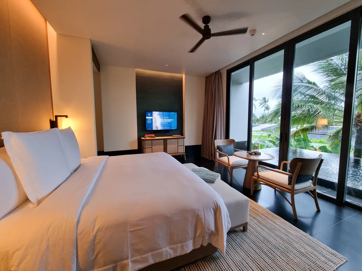 Bedroom with a view of the private pool through glass doors in a Terrace Pool Villa at Regent Phu Quoc