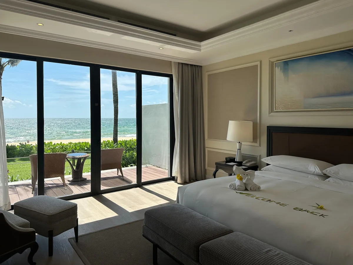 Pool villa bedroom with beach-view sliding doors and a Welcome Back towel art, Sheraton Phu Quoc