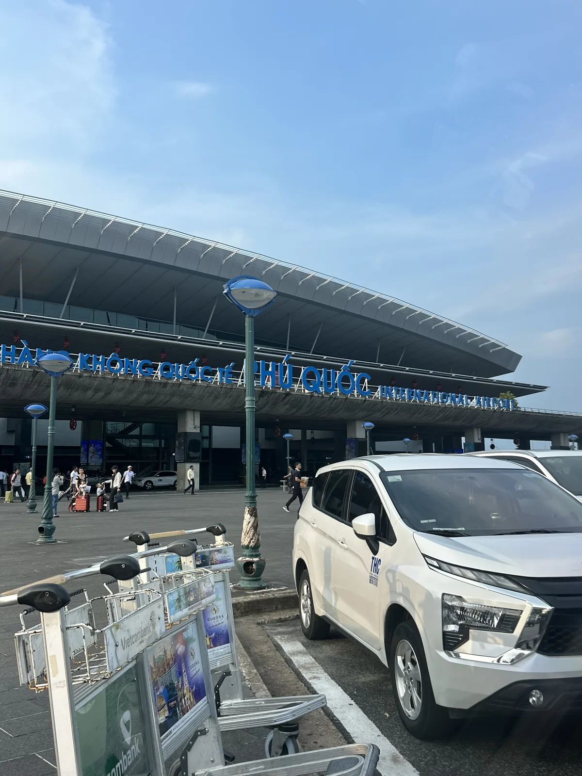 White private car waiting outside Phu Quoc International Airport terminal