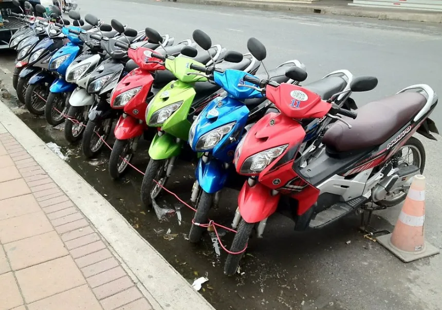 Row of colorful rental motorbikes parked along a street curb in Phu Quoc